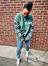 Load image into Gallery viewer, Green crewneck sweatshirt with Cool Creative logo and patches with black historical figures on the sleeves