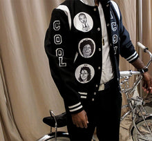 Load image into Gallery viewer, Black and white varsity jacket with chenille letter patch and patches with drawings on them men